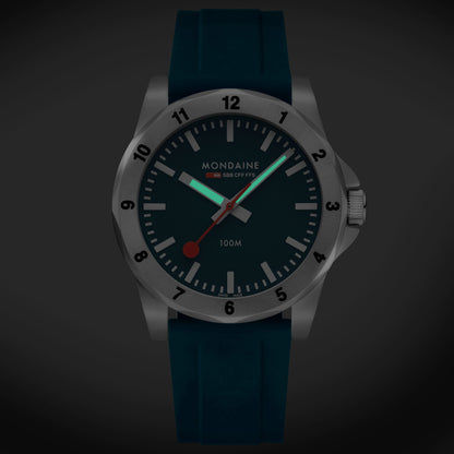 Montre homme de face avec bracelet en silicone bleu, cadran bleu foncé et aiguilles rouges.