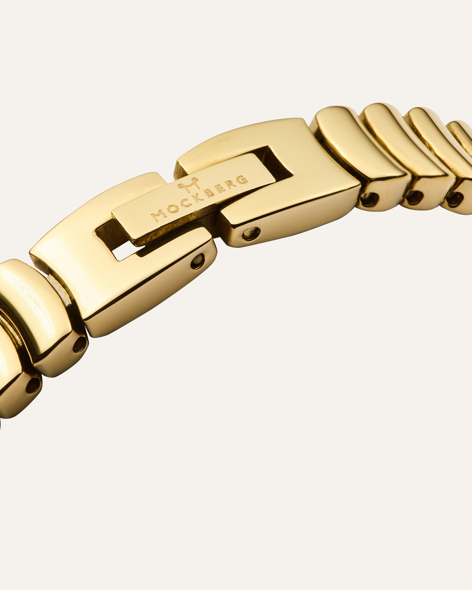 Goldfarbene Schließe und Logo-Elemente am Metallarmband der Armbanduhr