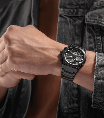 Chronographen-Uhr am Handgelenk mit schwarzem Armband, getragen zu Jeans