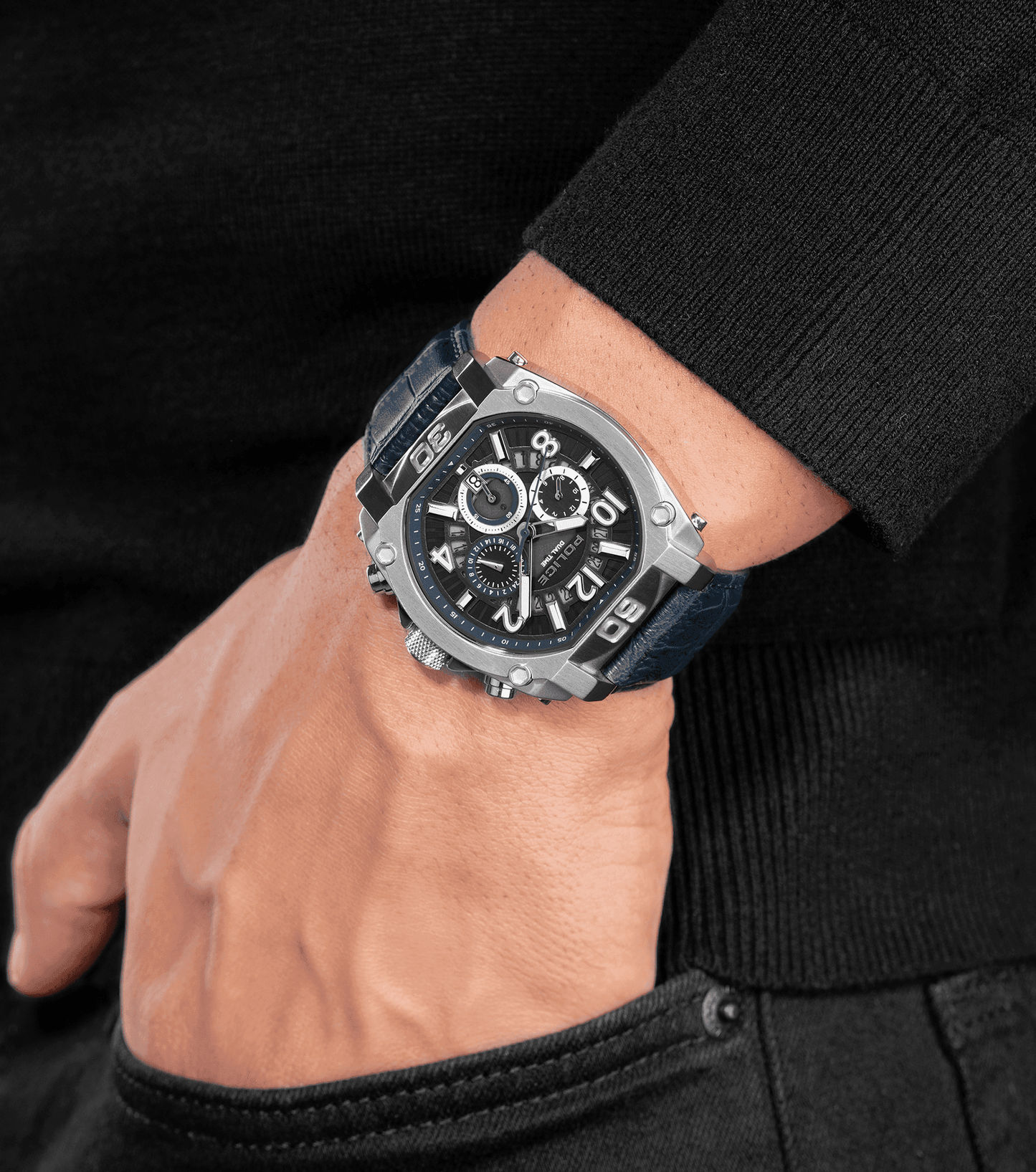 Herrenuhr am Handgelenk: blaues Lederarmband, silbernes Gehäuse, dunkles Zifferblatt