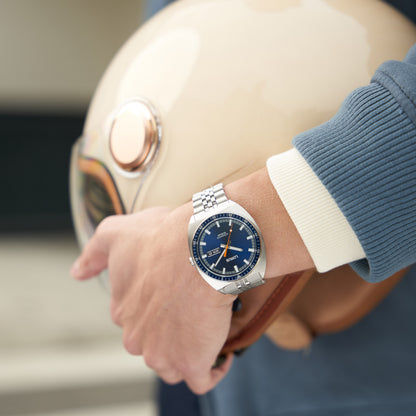 Armbanduhr mit blauem Zifferblatt, Edelstahlband und Datumsfenster, am Handgelenk