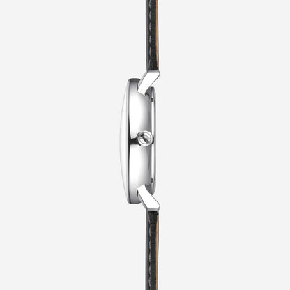 Montre homme de profil : boîtier argenté avec couronne et bracelet en cuir noir.