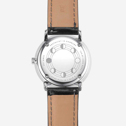 Fond de montre pour homme avec gravure circulaire et bracelet en cuir noir.