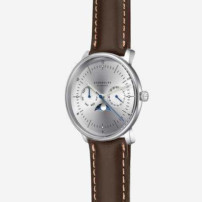 Montre Sternglas pour homme avec bracelet en cuir marron, boîtier argenté et compteurs bleus.