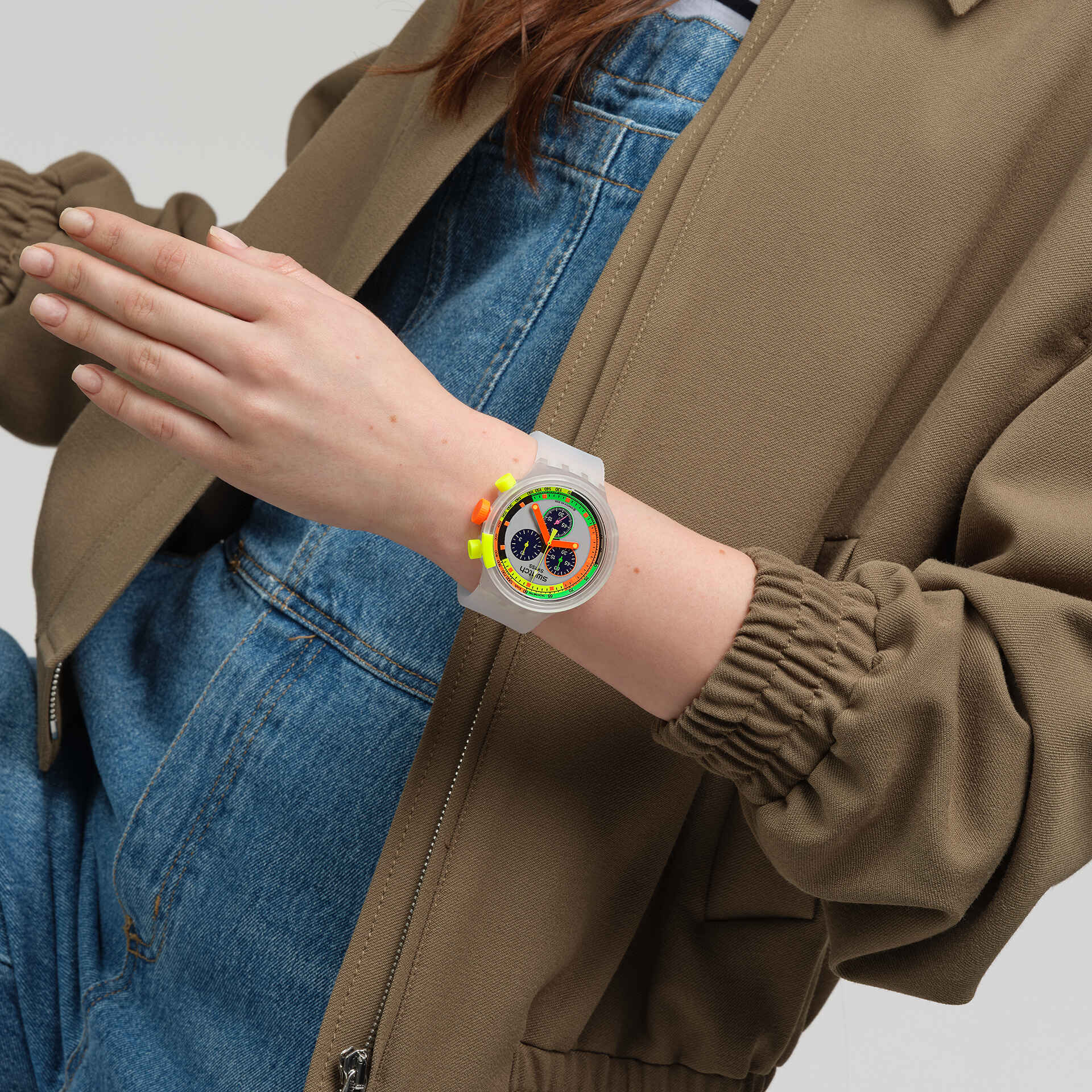 Damen-Armbanduhr am Handgelenk, transparentes weißes Band, farbiges Zifferblatt