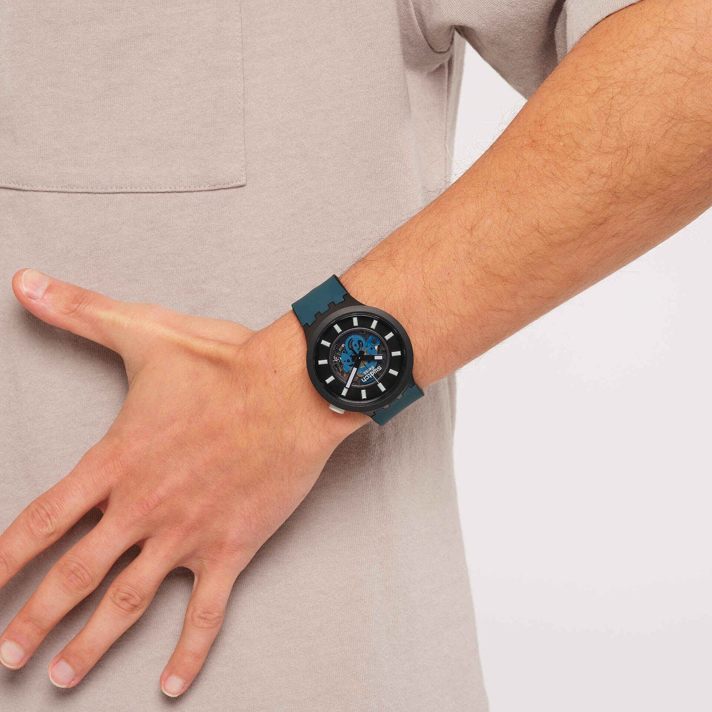 Swatch Herrenuhr am Handgelenk, blaues Armband, dunkles Zifferblatt mit Ziffernmarkern