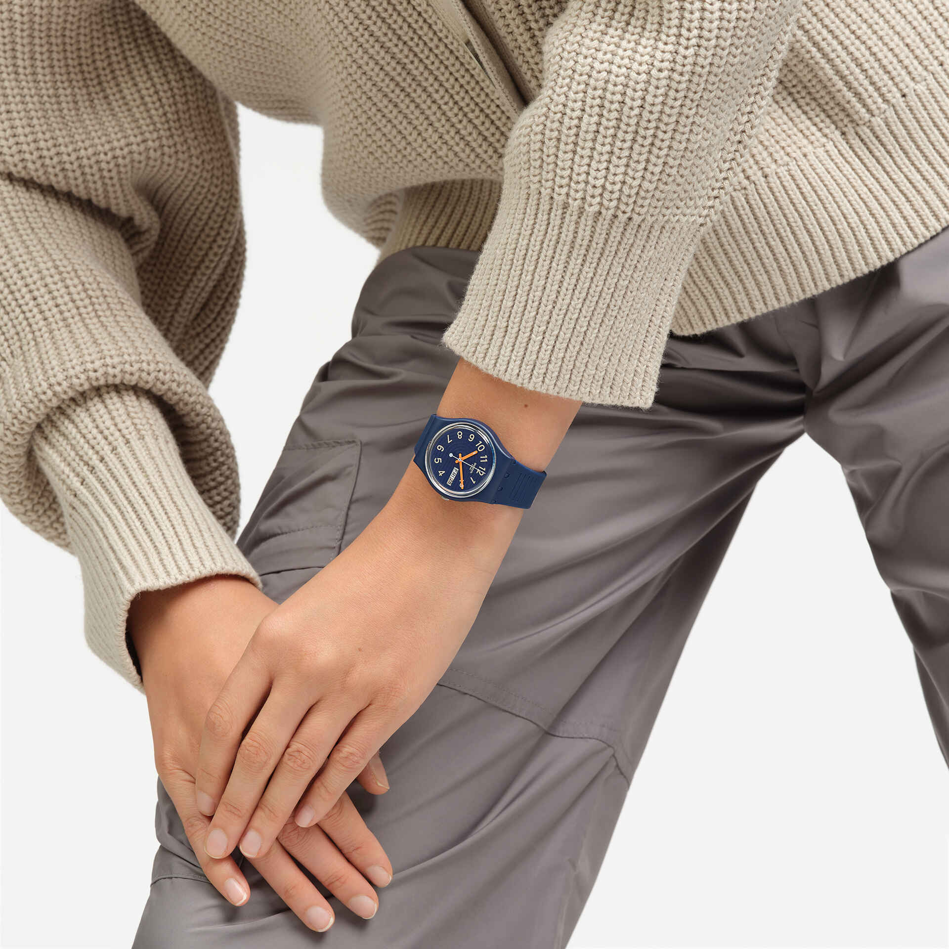 Dunkelblaue Armbanduhr am Handgelenk mit blauem Zifferblatt und Datumsanzeige