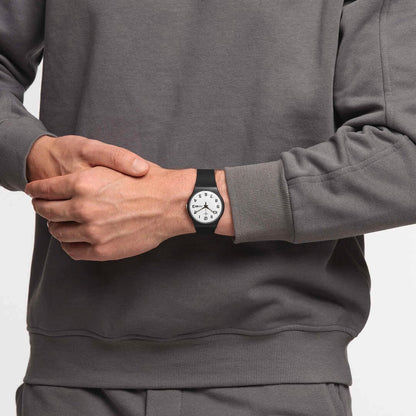 Armbanduhr am Handgelenk: schwarzes Armband, weißes Zifferblatt mit Tages-/Datumsanzeige