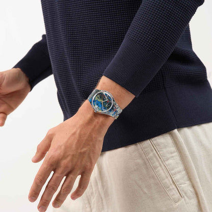 Armbanduhr mit transparentem Gehäuse und buntem Zifferblatt am Handgelenk