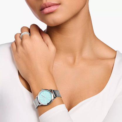 Damenuhr am Handgelenk mit türkisfarbenem Zifferblatt und silbernem Mesh-Armband