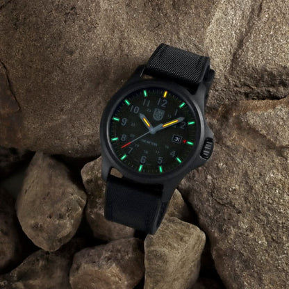 Montre pour homme sur rochers : cadran noir avec index lumineux verts