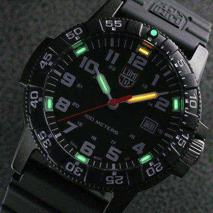 Montre pour homme : Gros plan sur un cadran noir avec des index verts lumineux et la date