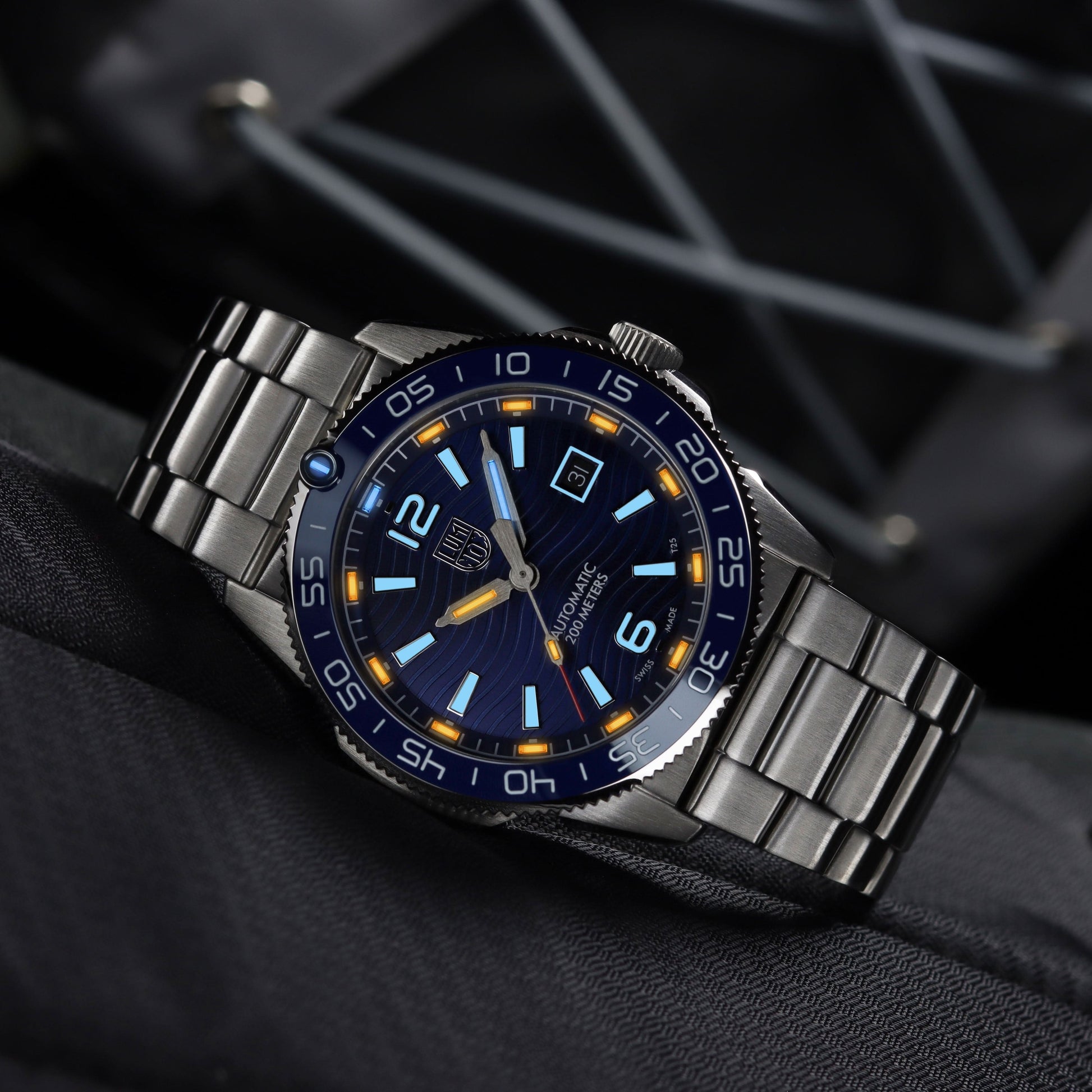 Montre bracelet en gros plan avec cadran bleu, index lumineux et affichage de la date.
