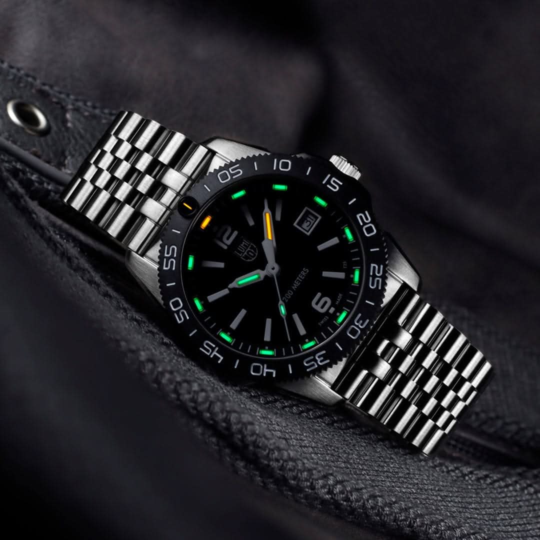 Montre homme avec cadran noir et bracelet en acier inoxydable argenté, index luminescents sur la lunette