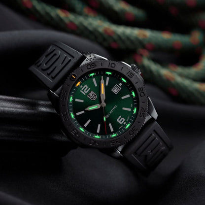 Montre homme avec bracelet en caoutchouc noir et cadran vert, aiguilles lumineuses visibles