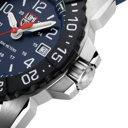 Gros plan du bord du boîtier : fond en acier inoxydable, zone de chronographe moletée et aspect cadran bleu foncé.