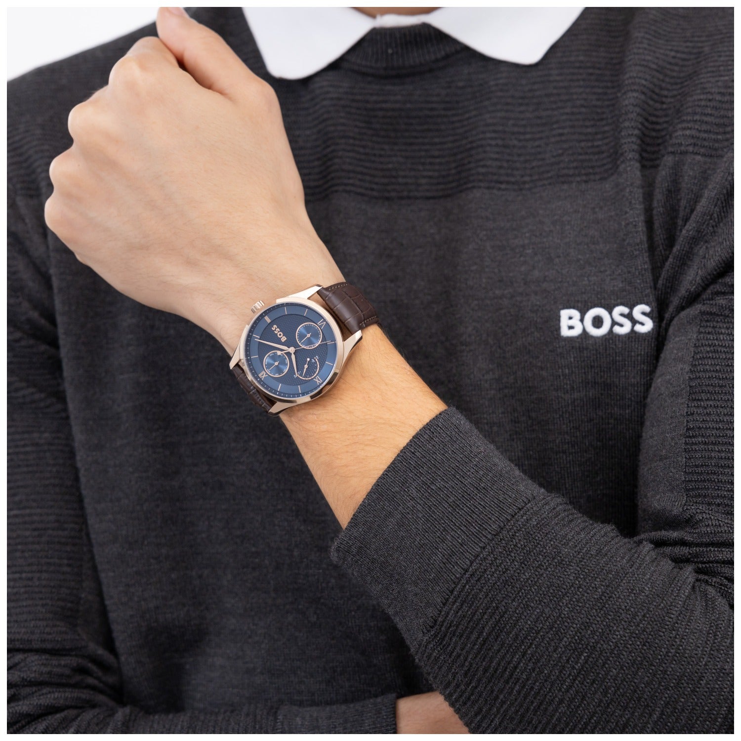 Herrenarmbanduhr mit rundem blauem Zifferblatt und braunem Lederarmband am Handgelenk