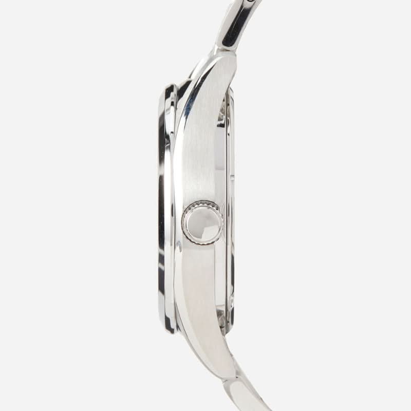 Vue de côté d'une montre pour homme en acier inoxydable avec couronne sur un boîtier rond