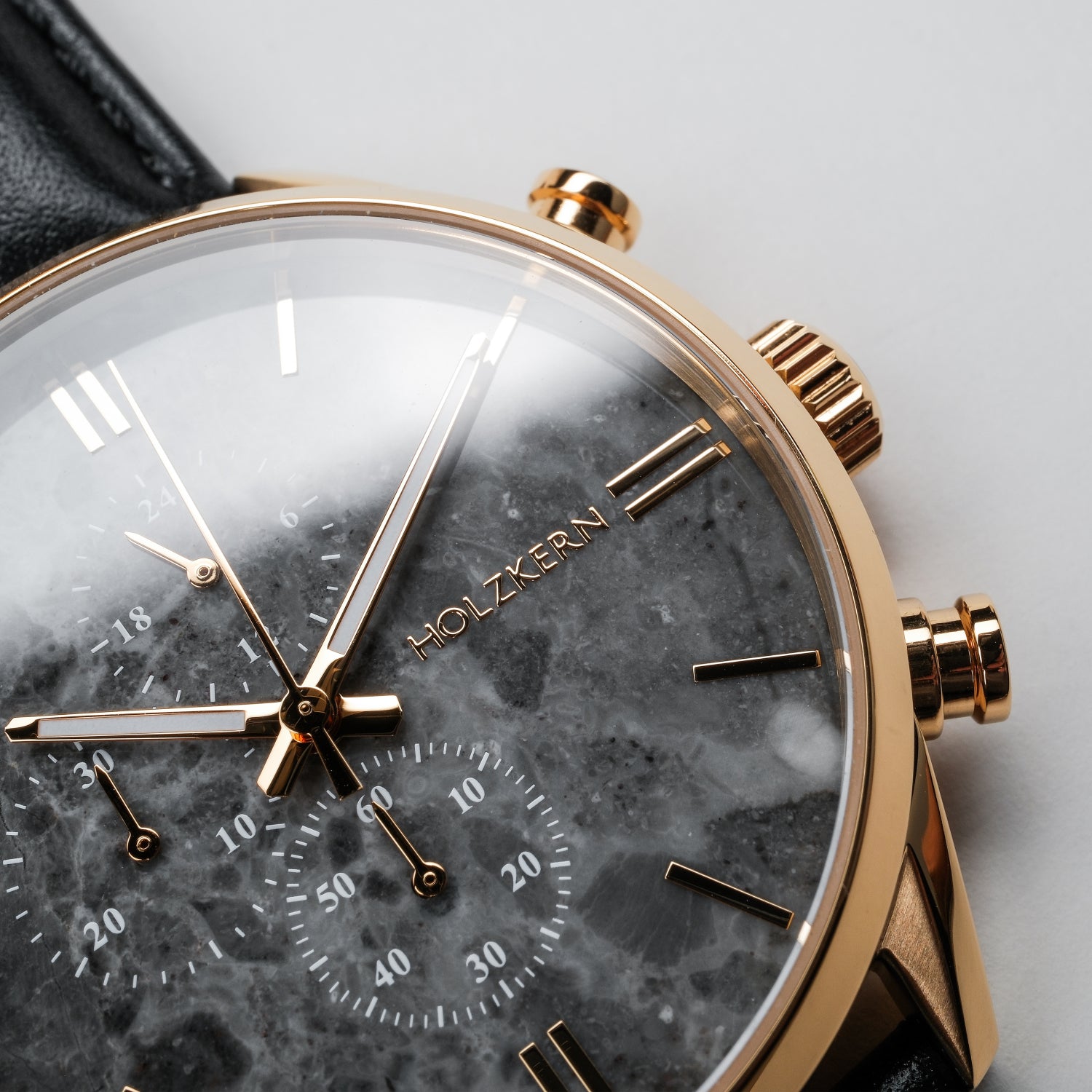Holzkern Armbanduhr Detailansicht: goldenes Lünette-Design, Marmorzifferblatt, schwarzes Band