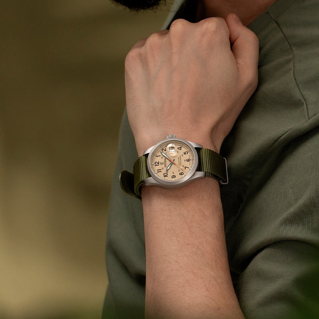 Festina Herrenuhr am Handgelenk mit grünem Textilarmband und silbernem Gehäuse