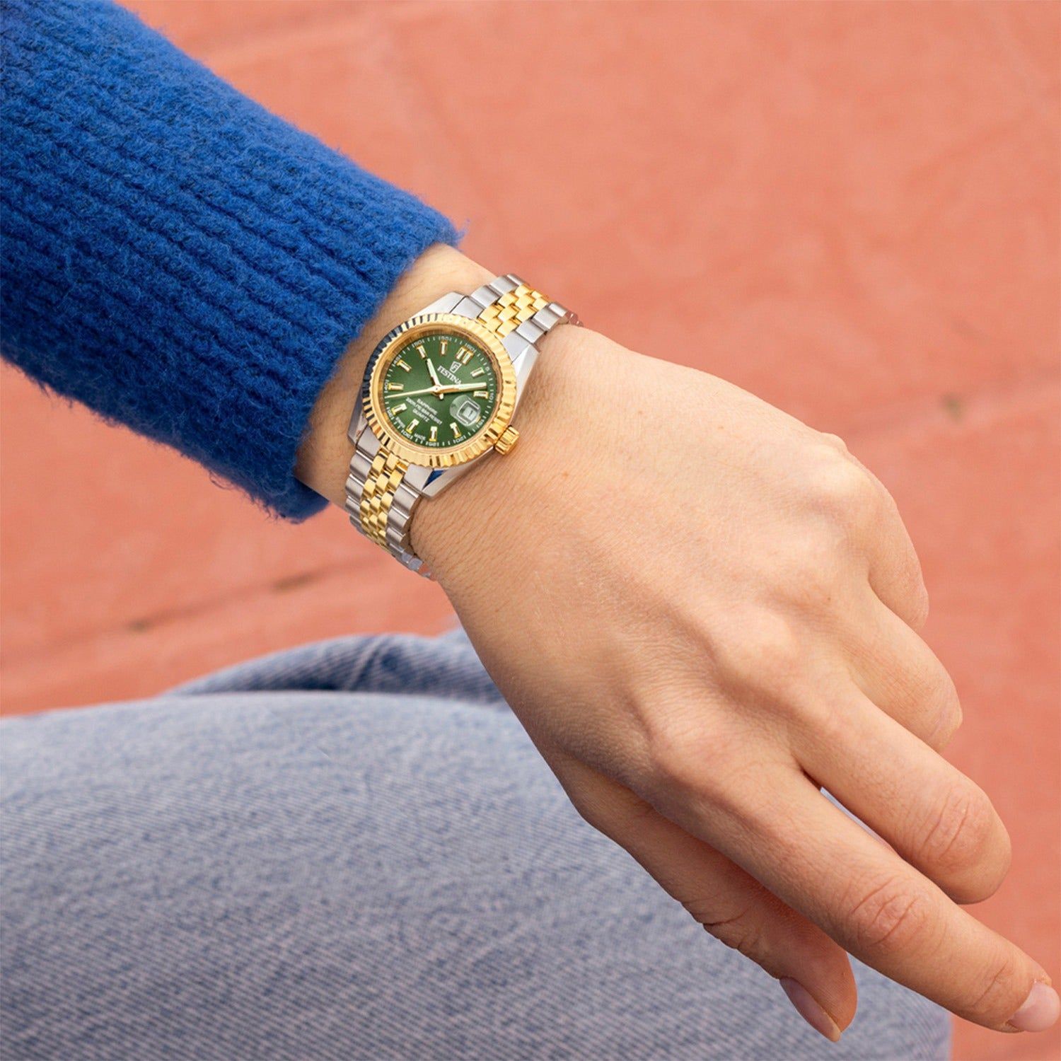 Damenuhr mit bicolor Stahlarmband und moosgrünem Zifferblatt, am Handgelenk.