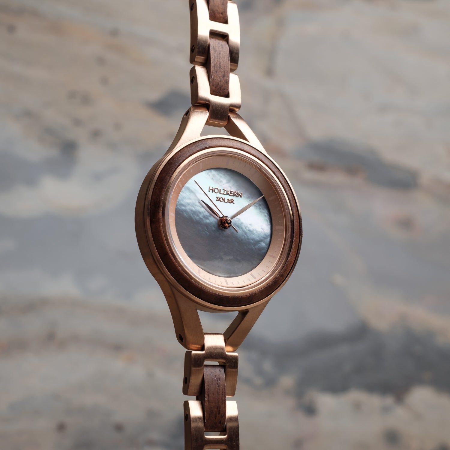 Damenarmbanduhr mit roséfarbenem Gehäuse und blauem Zifferblatt, seitliche Ansicht des Armbands