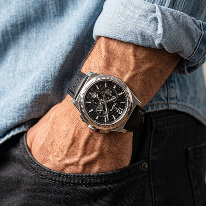 Herrenarmbanduhr am Handgelenk: schwarzes Zifferblatt, Stahlgehäuse, schwarzes Lederband