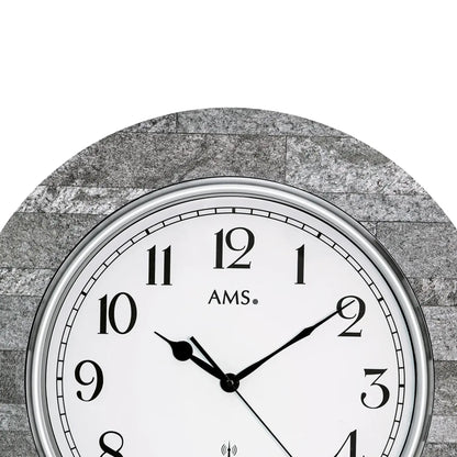 Wanduhr mit grauer Stein-Optik, silbernem Rand, weißem Ziffernblatt mit AMS.