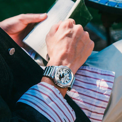 Armbanduhr G‑SHOCK am Handgelenk mit silbernem Edelstahlband und großem Zifferblatt