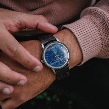 Holzkern Armbanduhr am Handgelenk mit blauem Zifferblatt und schwarzem Holzarmband