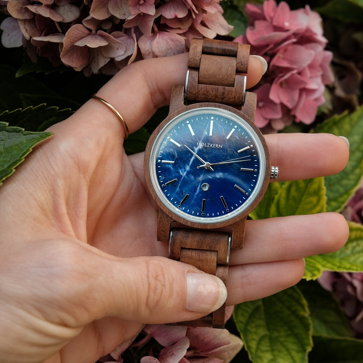 Holzkern Armbanduhr am Handgelenk: blaues Zifferblatt, braunes Holzarmband