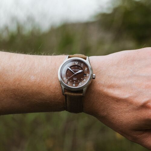 Holzkern Wildlight Solararmbanduhr am Handgelenk, braunes Band und grünlich-braunes Zifferblatt