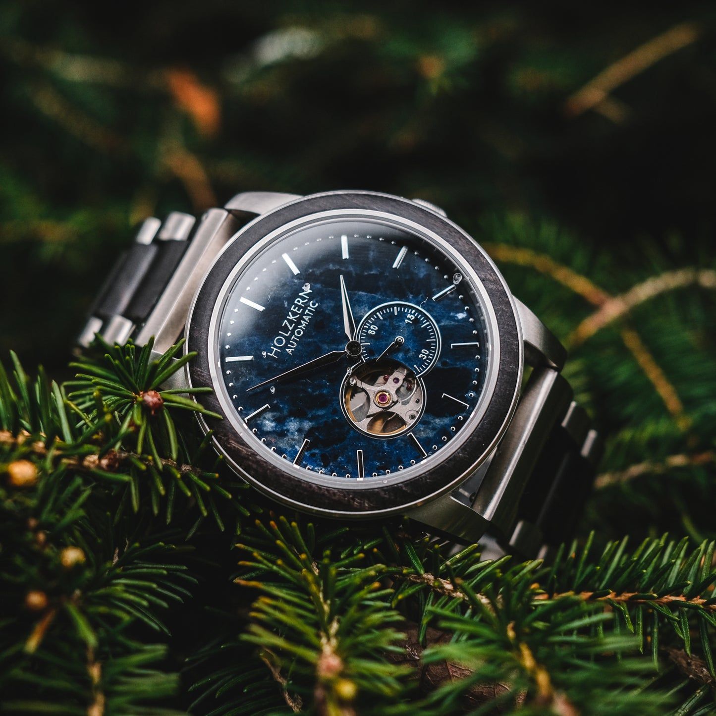 Herrenuhr mit silbernem Edelstahlgehäuse, blauem Zifferblatt und offenem Automatikwerk