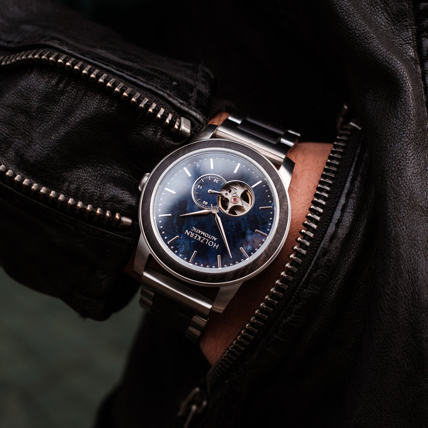 Herrenuhr: silbernes Stahlarmband, blaues Zifferblatt und sichtbares Automatikwerk
