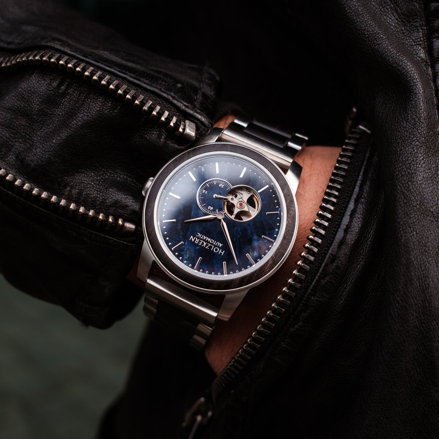 Herrenuhr: silbernes Stahlarmband, blaues Zifferblatt und sichtbares Automatikwerk