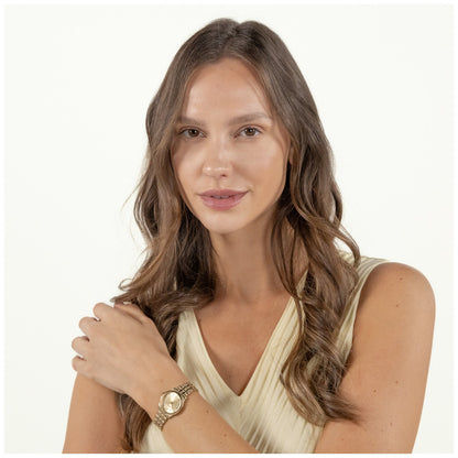Damenarmbanduhr am Handgelenk, rundes goldfarbenes Zifferblatt, Gliederarmband mit Faltschließe.