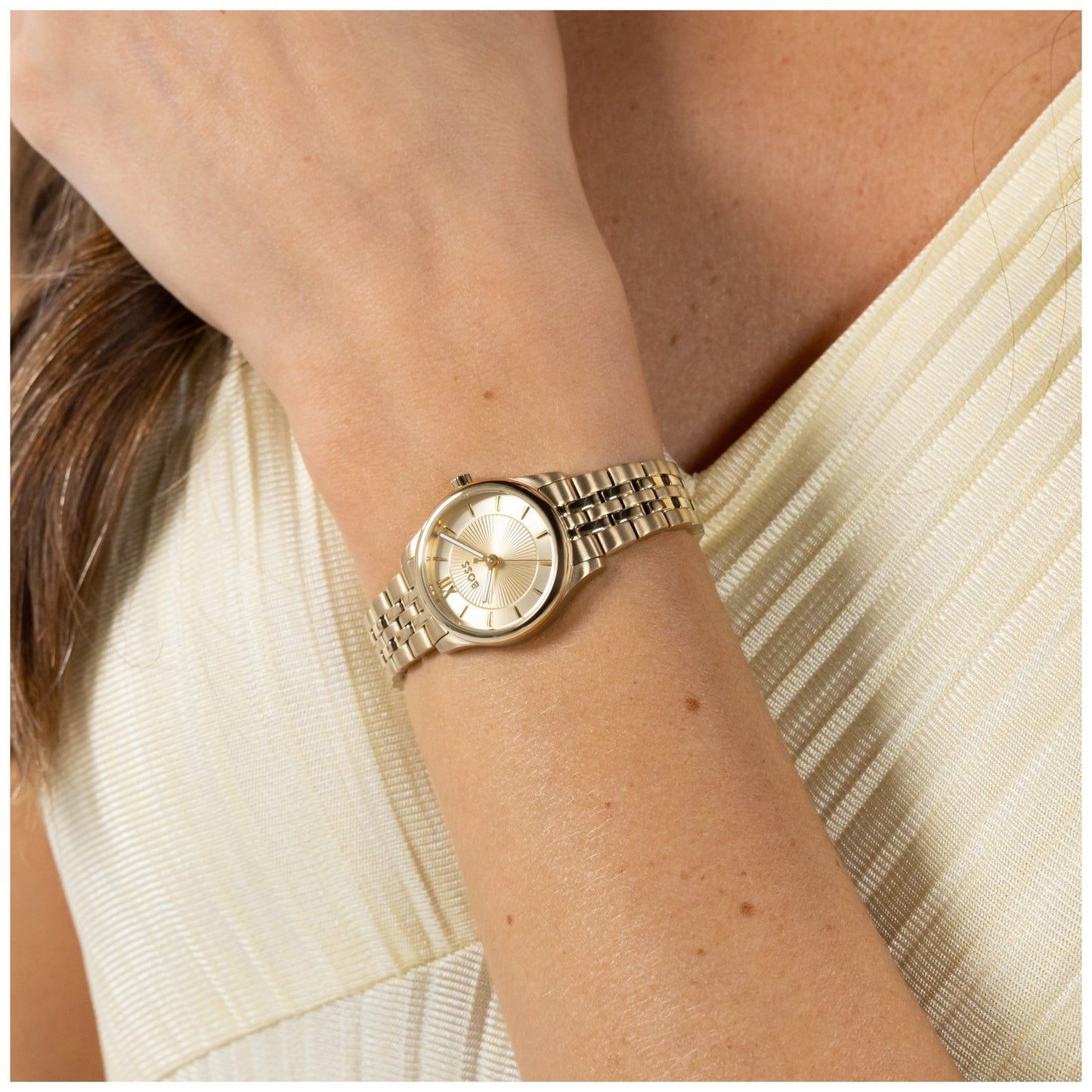 Damenarmbanduhr: rundes goldfarbenes Zifferblatt mit Metallarmband und Faltschließe.