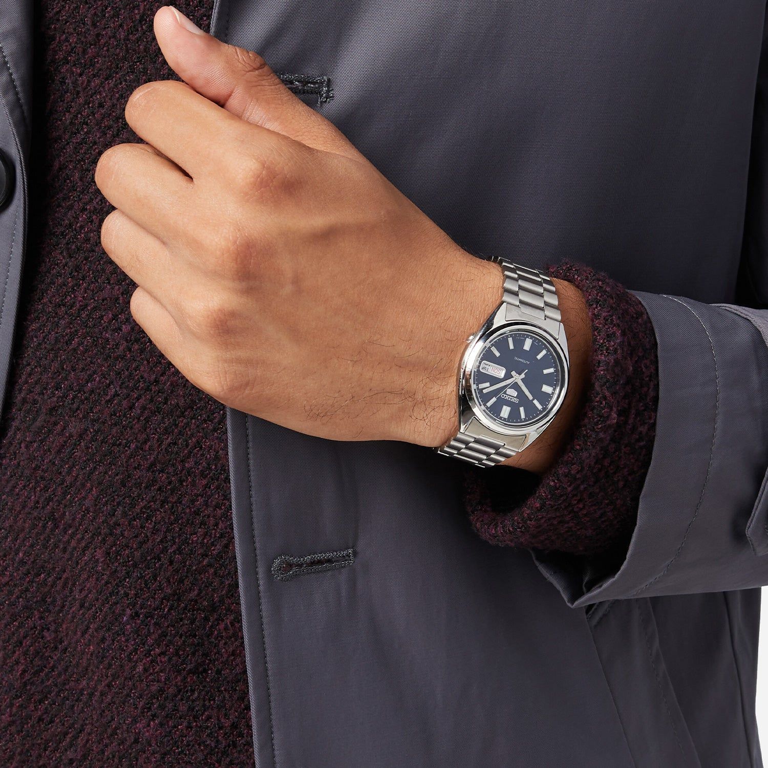 Herrenarmbanduhr mit blauem Zifferblatt und silbernem Stahlarmband am Handgelenk