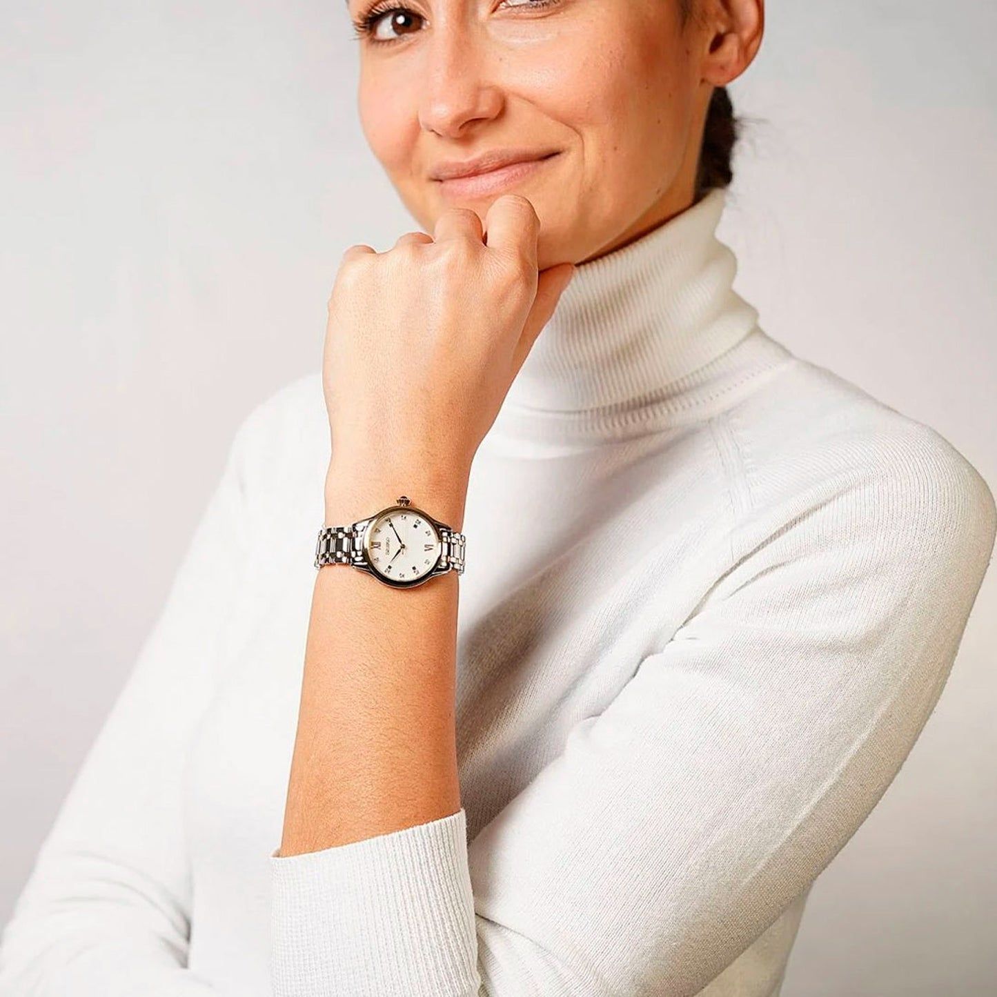 Seiko Damenarmbanduhr am Handgelenk, silber-goldenes Edelstahlband, rundes Zifferblatt