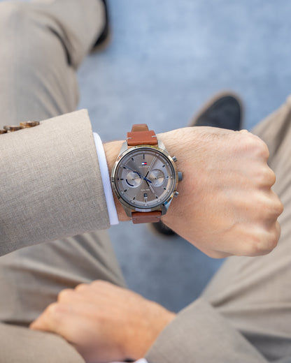 Herrenarmbanduhr am Handgelenk: graues Zifferblatt, braunes Lederarmband, analog