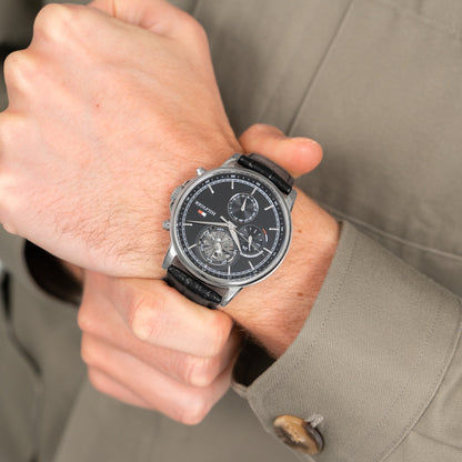 Herrenquarzuhr mit schwarzem Skeleton-Zifferblatt und schwarzem Lederarmband, am Handgelenk