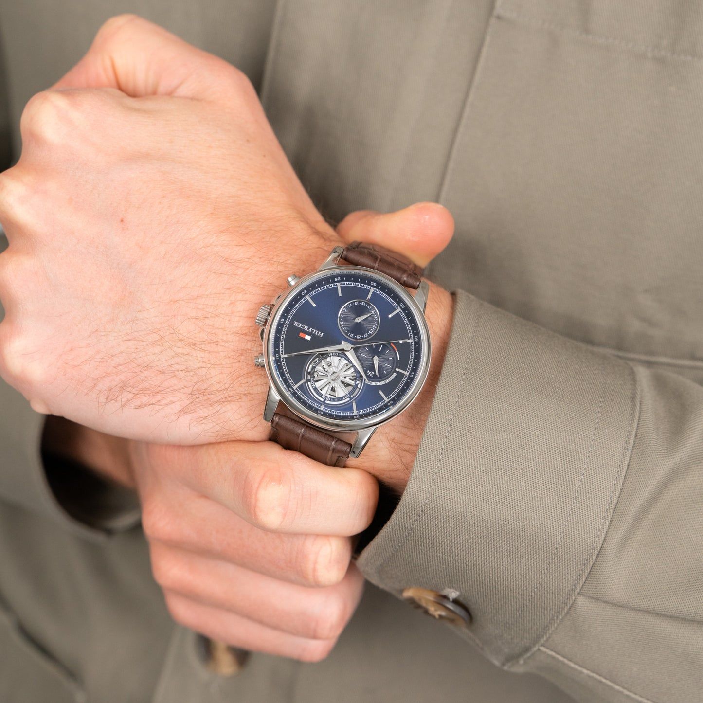 Herrenarmbanduhr am Handgelenk, blaues Zifferblatt mit Subdials, braunes Lederband.