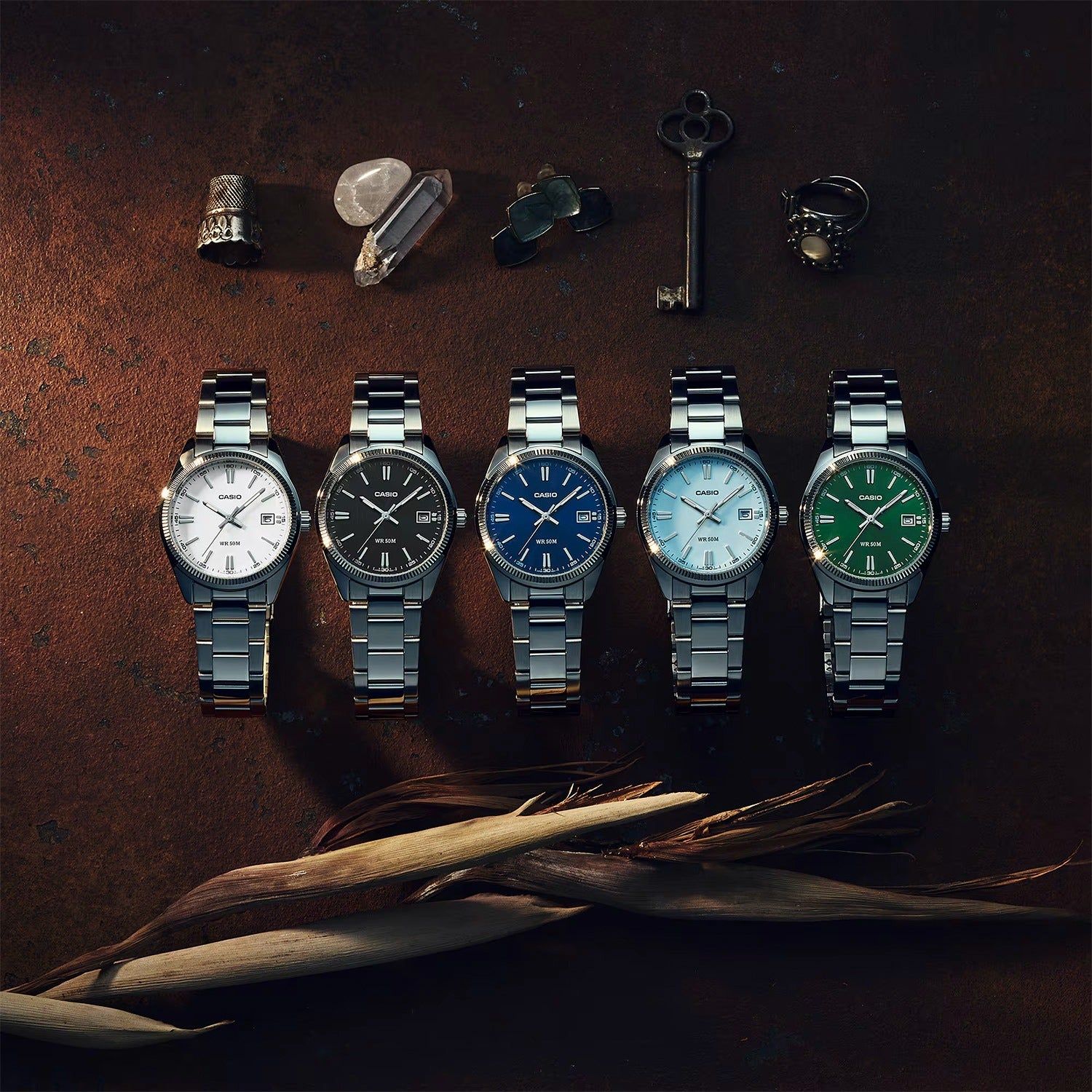 Mehrere Casio Armbanduhren mit Metallarmband und rundem Gehäuse aufgereiht