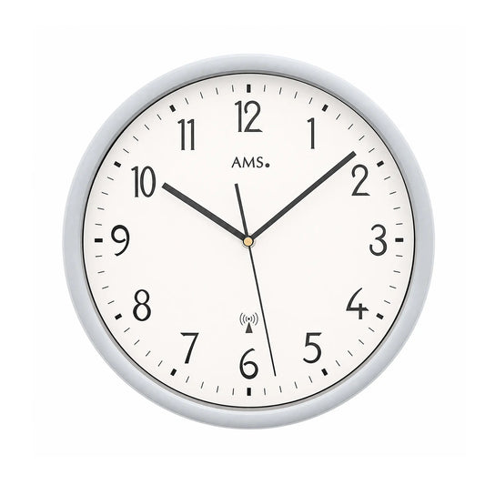 Horloge murale avec cadran blanc, aiguilles noires et cadre argenté