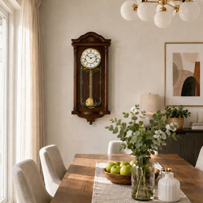 Wanduhr aus dunklem Holz an der Wand mit rundem weißem Zifferblatt und Pendel
