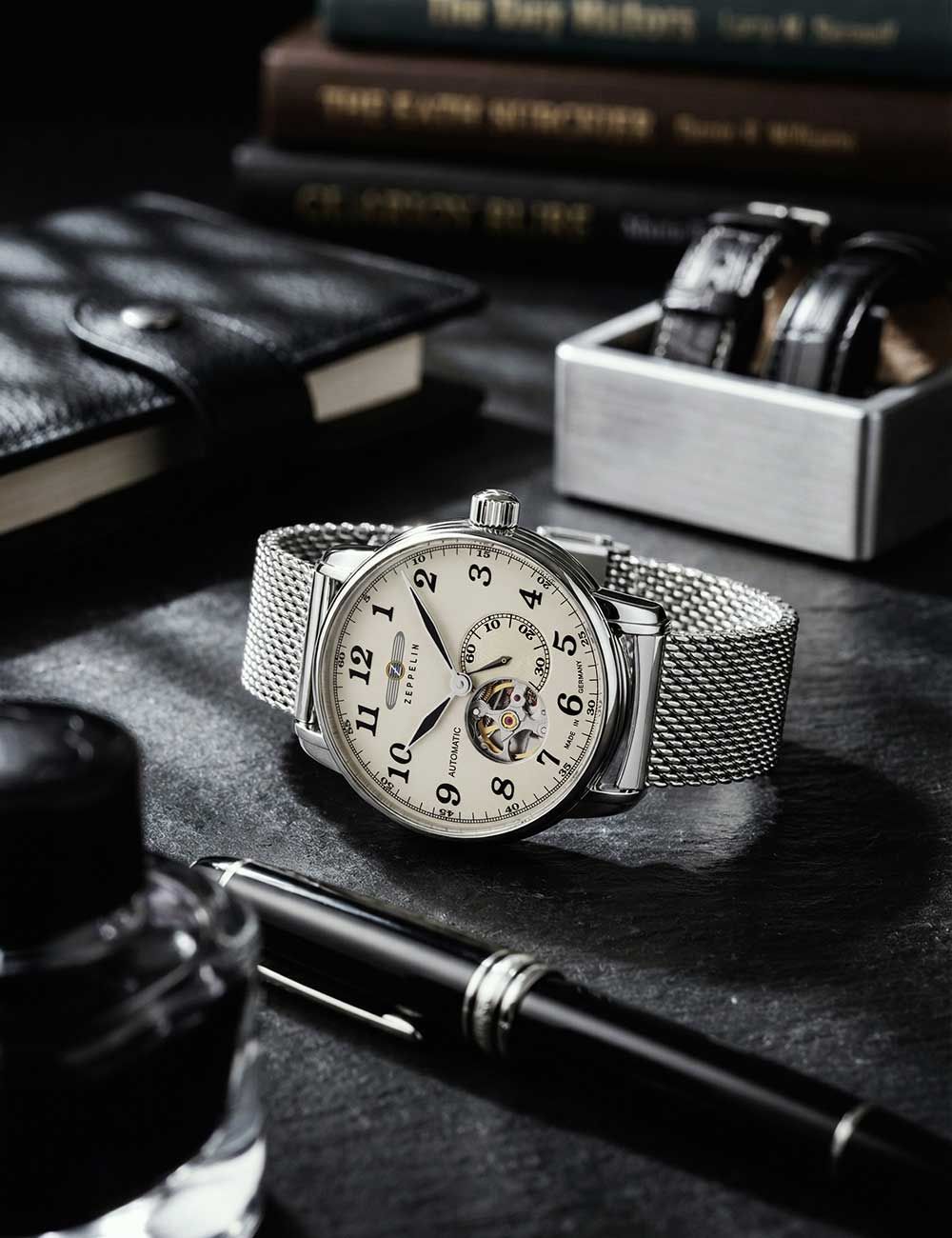 Zeppelin Herrenuhr: silbernes Meshband, helles Zifferblatt mit sichtbarem Uhrwerk