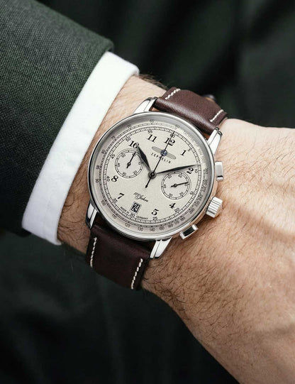 Zeppelin Herrenarmbanduhr am Handgelenk: beiges Zifferblatt, braunes Lederband, silbernes Gehäuse