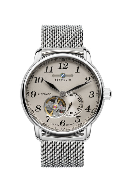 Herrenuhr mit beigem Zifferblatt, offenem Herz, silbernem Gehäuse und Metallarmband.