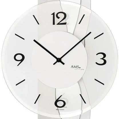 Wanduhr im Detail: weißes Zifferblatt mit schwarzen Zahlen, Zeigern und AMS-Schriftzug