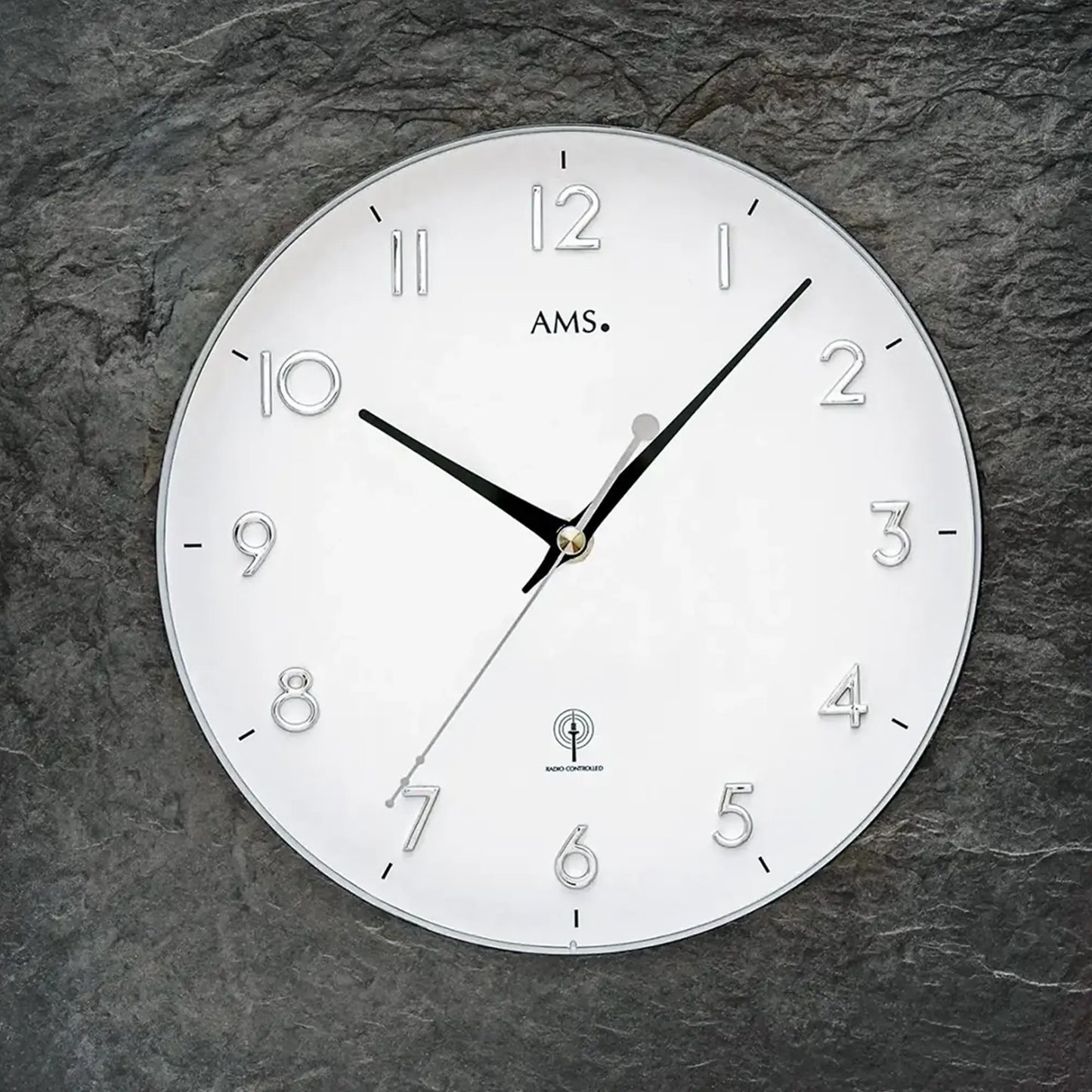 Nahansicht: runde Funk-Wanduhr mit naturschiefergrauem Rand und Mineralglas